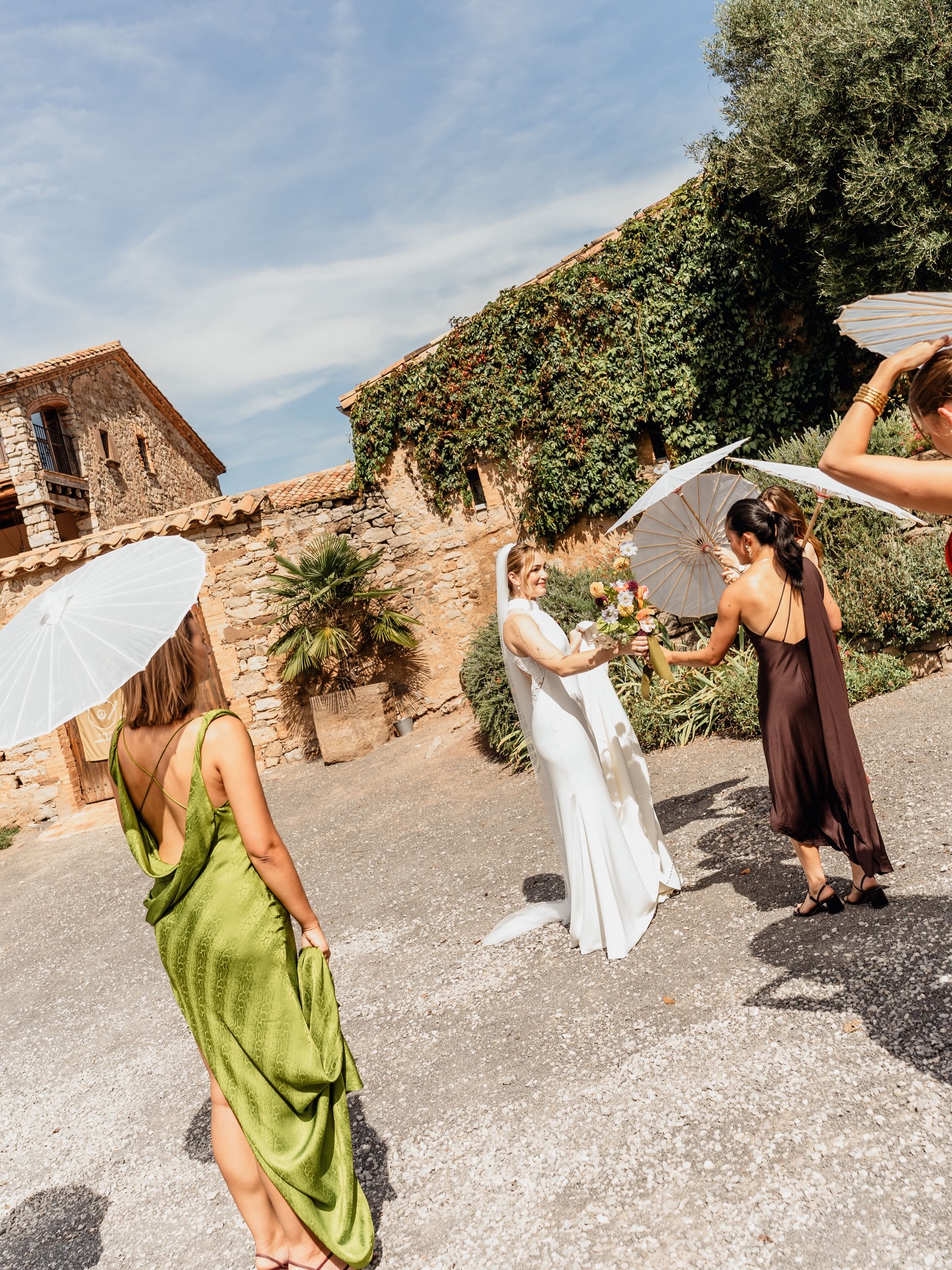 La novia recibida por sus invitadas en el patio de piedra de la masía — reportaje de boda fine art