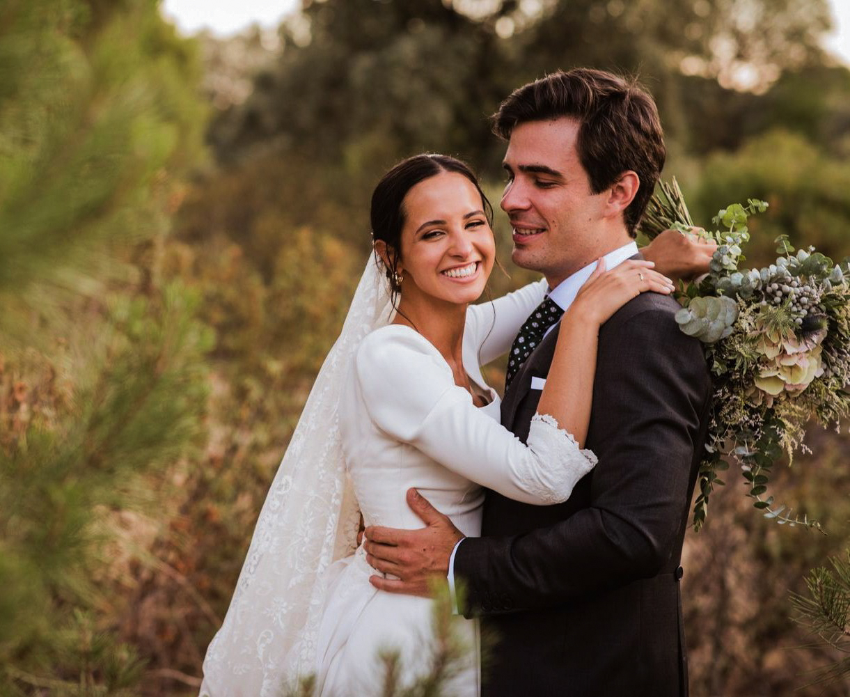 Novios abrazándose en el campo, la novia sonriendo con el ramo de novia — fotógrafo de bodas fine art en Gandia